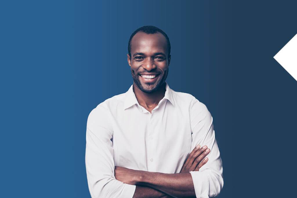 Man in a white collar shirt crossing arms and smiling