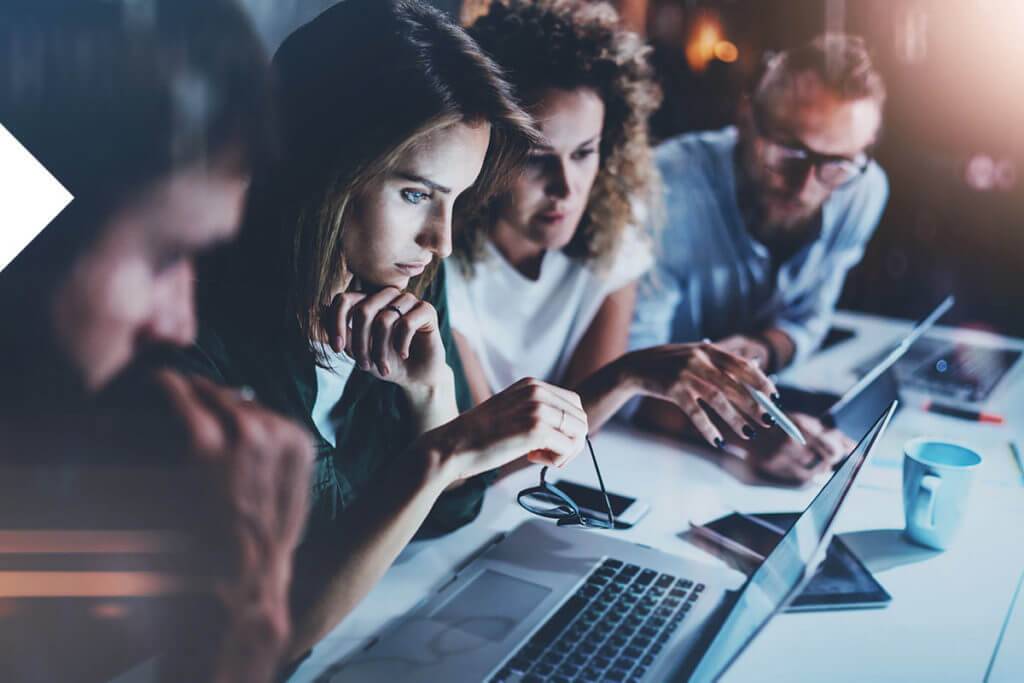 Four people looking at a computer