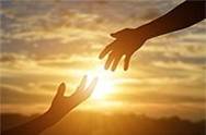 Hands reaching towards each other with sunshine in the background